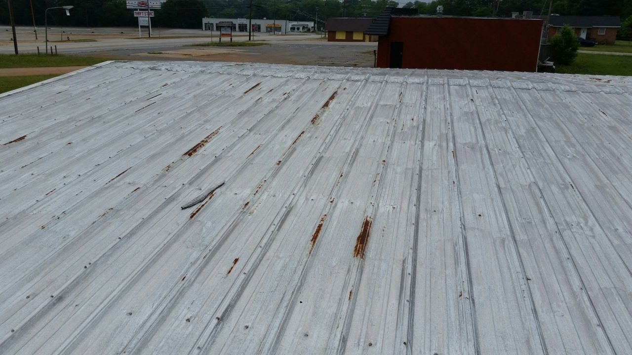 Roof coating in progress — partial application on metal roof
